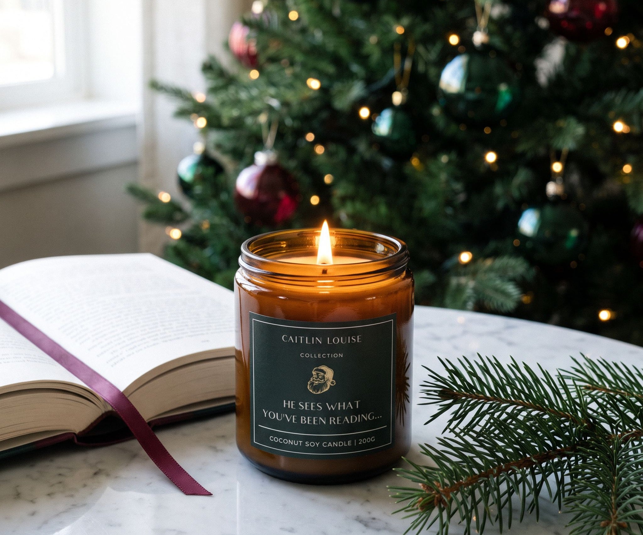 Christmas bookish candle on marble table with open book nearby and christmas tree background
