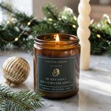 christmas bookish candle on marble table with christmas wreath in background