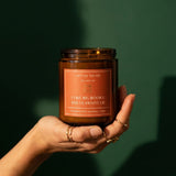 Bookish candle held in hand on emerald background