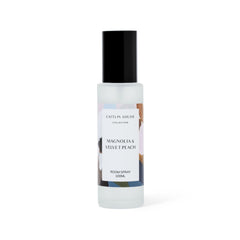Room spray bottle labeled 'Caitlin Louise Collection Magnolia & Velvet Peach' on a white background
