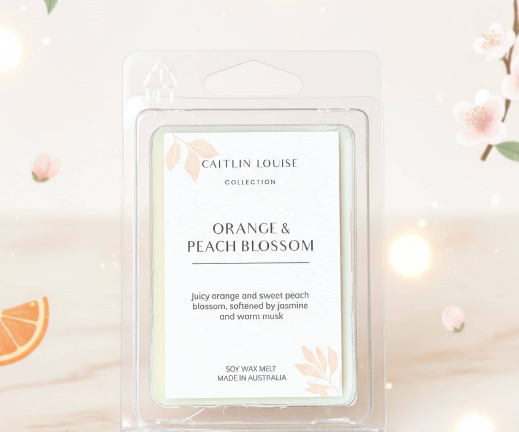 Caitlin Louise Orange & Peach Blossom wax melt packaging on a decorative background with flowers and oranges.