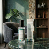 Palm Leaf and Sea Mist room spray with box on a green marble table