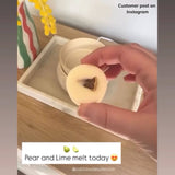Hand holding a wax melt disk with a dried lime center on a wooden surface, with text indicating a customer post on Instagram.