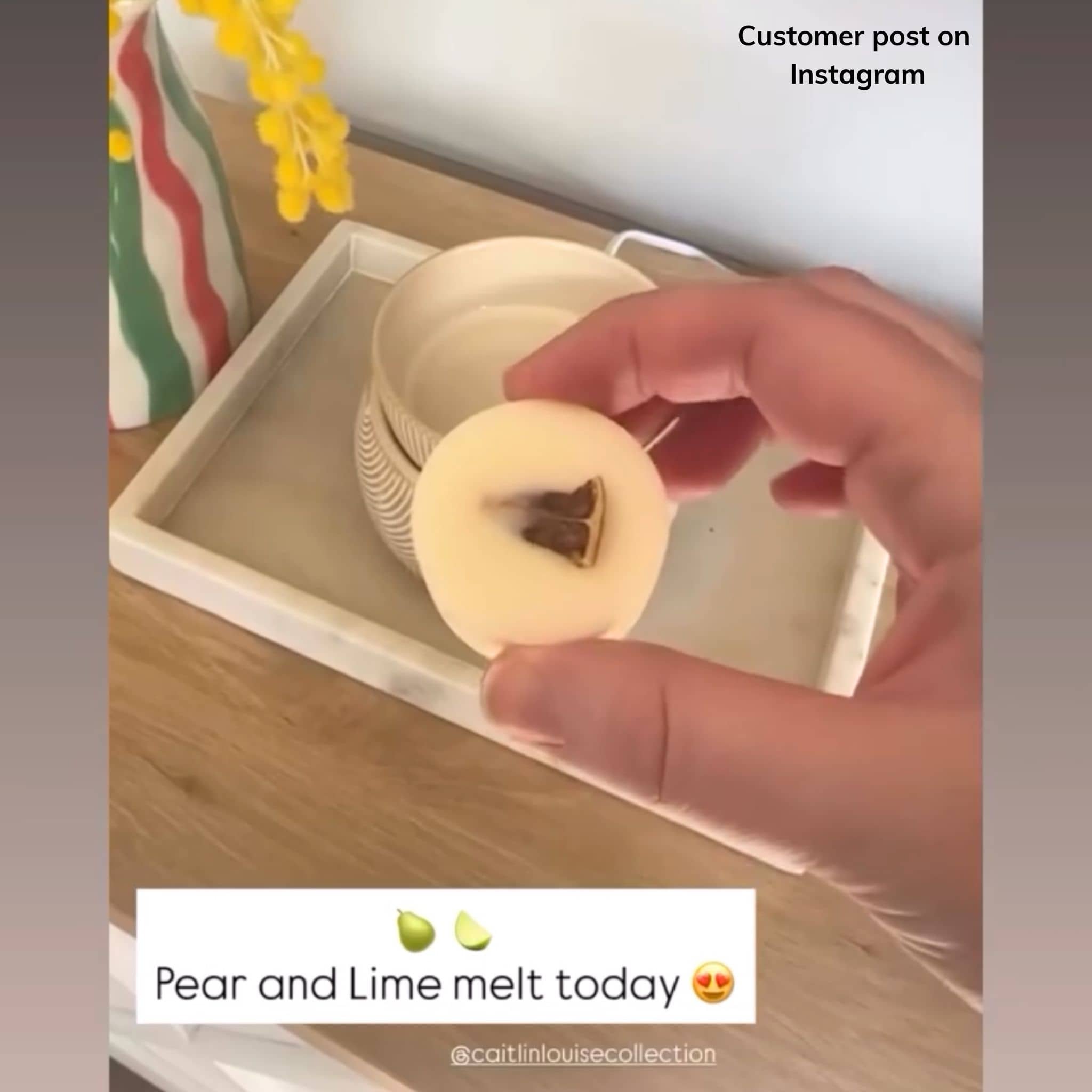 Hand holding a wax melt disk with a dried lime center on a wooden surface, with text indicating a customer post on Instagram.
