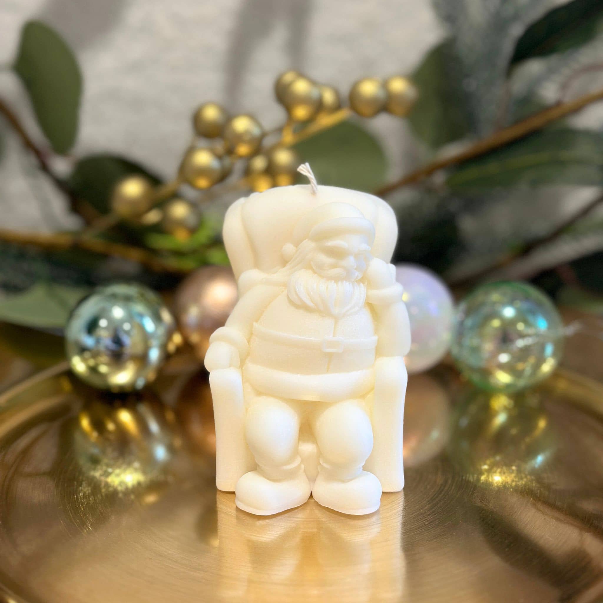 Caitlin Louise Collection resting Santa sculptural candle - on gold plate with wreath in background