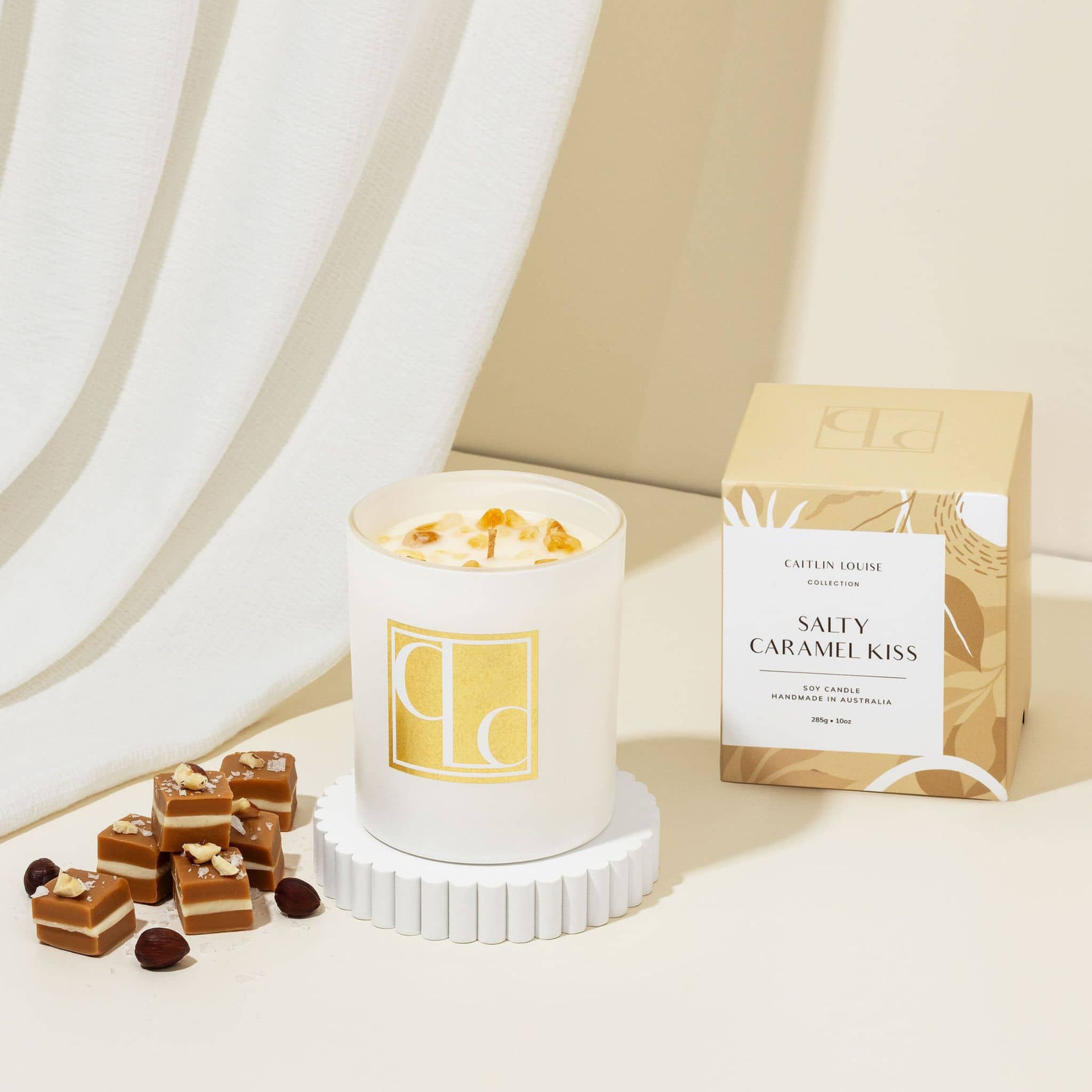 Salted Caramel Candle with 'Caitlin Louise Collection' branding and a box labeled 'Salty Caramel Kiss' on a light background.