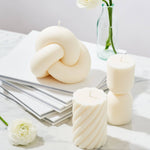 Caitlin Louise Collection sculptural candles - Knot, Aurelia, Symphony styles on books with flowers