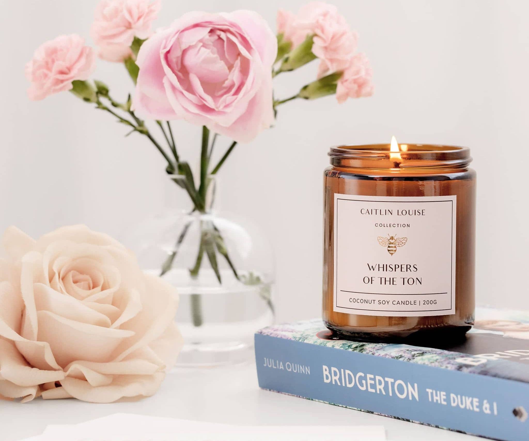 Caitlin Louise Collection Whispers of the Ton Bookish Candle - styled with flowers and Bridgerton book