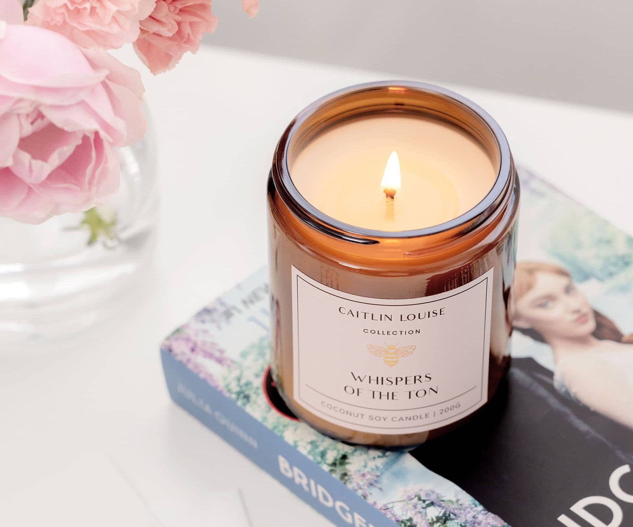 Caitlin Louise Collection Whispers of the Ton Bookish Candle - styled with flowers and Bridgerton book - close up