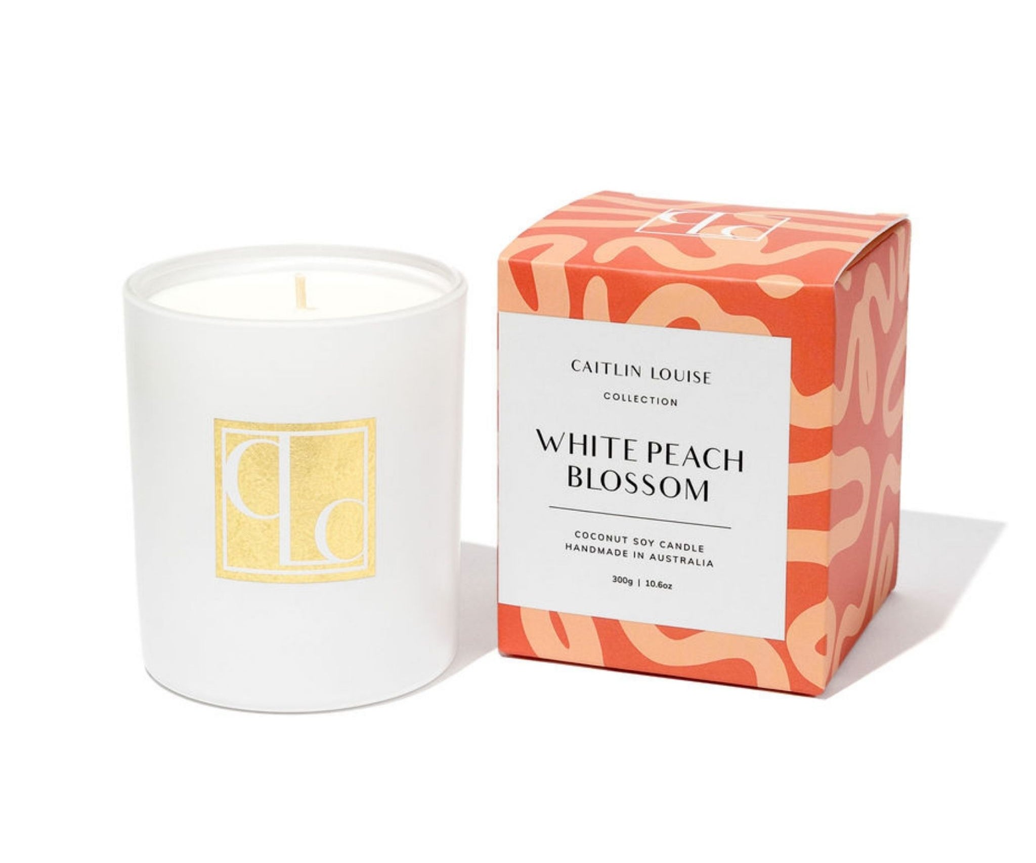 Caitlin Louise Collection White candle with a decorative box labeled 'White Peach Blossom' on a white background