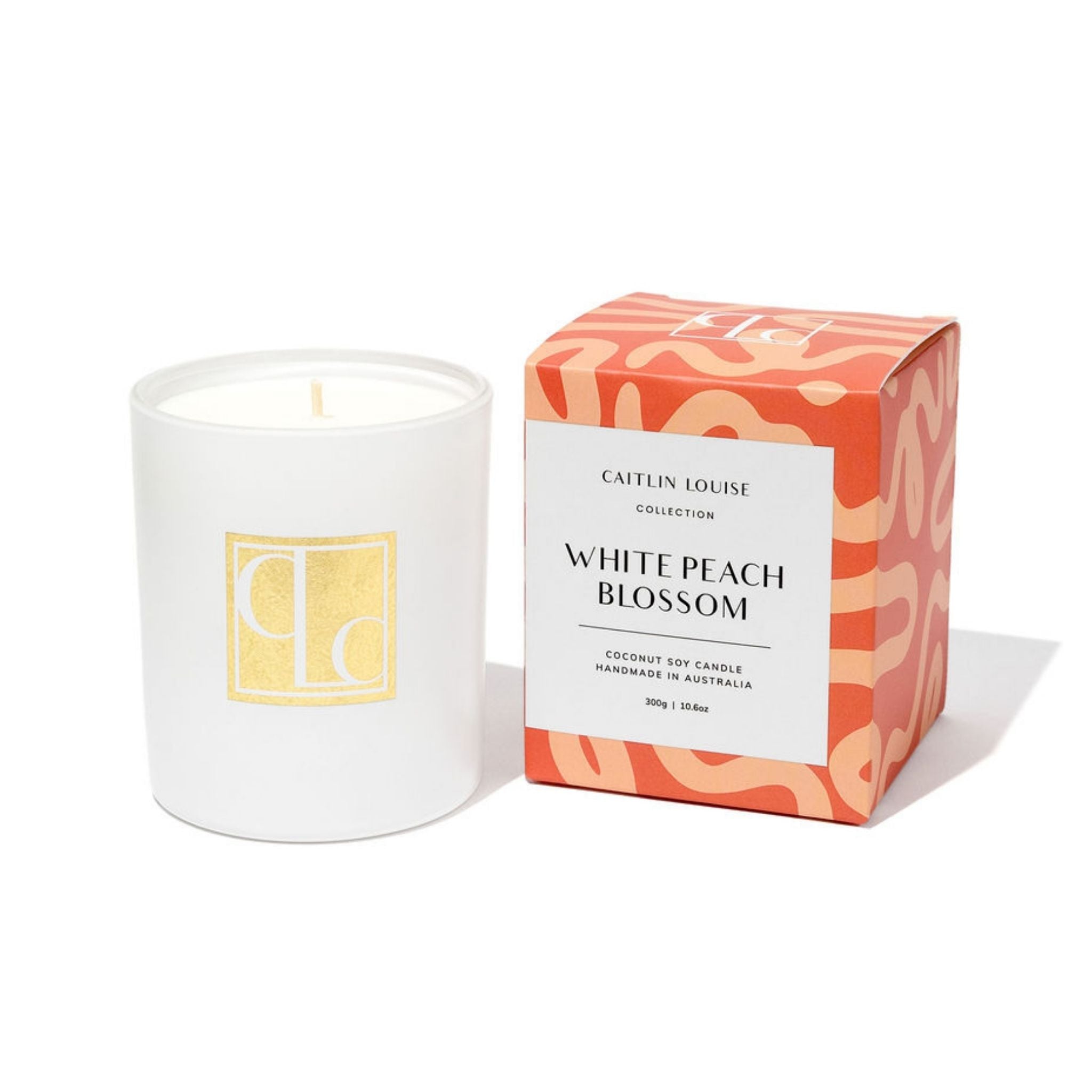 Caitlin Louise Collection White candle with a decorative box labeled 'White Peach Blossom' on a white background